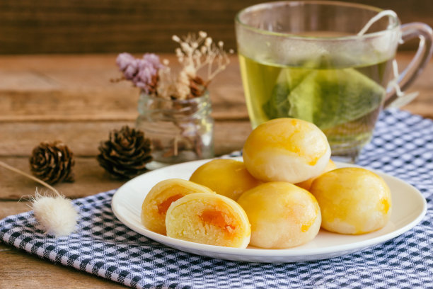 甜绿豆咸蛋的中式糕点。绿豆沙和咸蛋馅的月饼或中式糕点与绿茶一起食用。美味的自制中式糕点即将上桌。图片下载