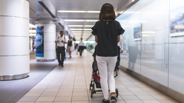 母亲和婴儿在地下城镇行走的后视图图片下载