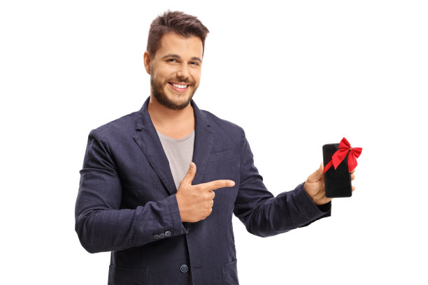 优雅的男子展示手机与红色的蝴蝶结作为礼物图片下载