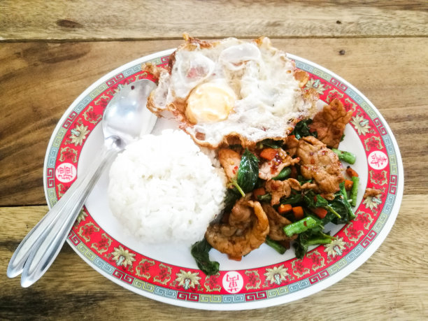 木桌上炒罗勒、猪肉、炒蛋和米饭图片下载