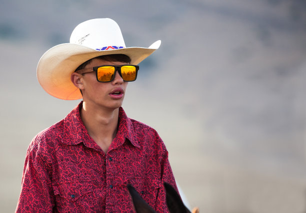 狂野西部年轻的牛仔，红色衬衫和凉爽的反光太阳镜素材图片