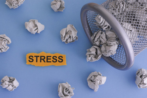 压力。从垃圾桶里滚出来的皱巴巴的灰色纸团图片下载