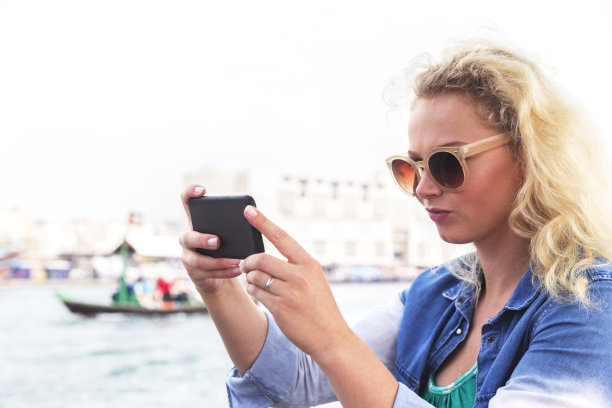 在迪拜河上乘船拍照的欧洲女孩图片下载