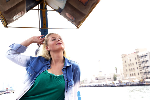 年轻女游客乘坐传统Abra船游览迪拜老城区图片下载