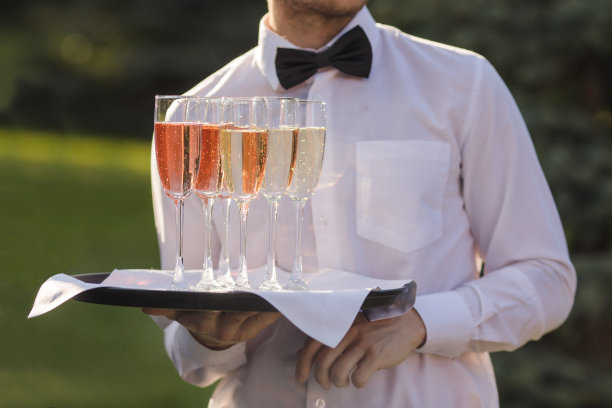 用托盘端香槟的侍者图片下载