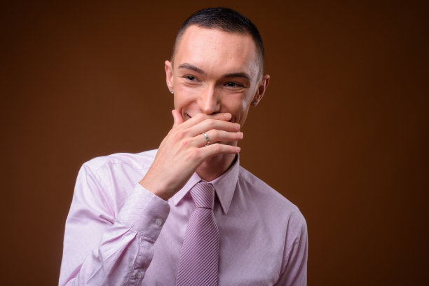 工作室拍摄的年轻英俊的中性商人穿着粉红色时尚的衣服，以彩色背景图片下载