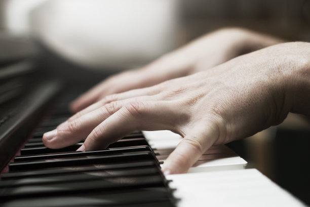 男人的手在弹钢琴的特写照片图片下载