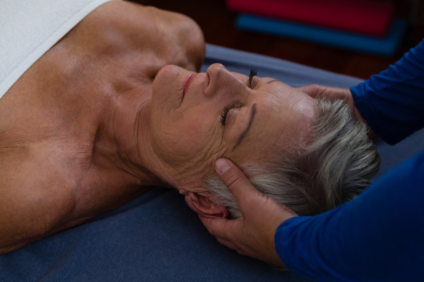 理疗师给一位老年妇女做头部按摩素材图片