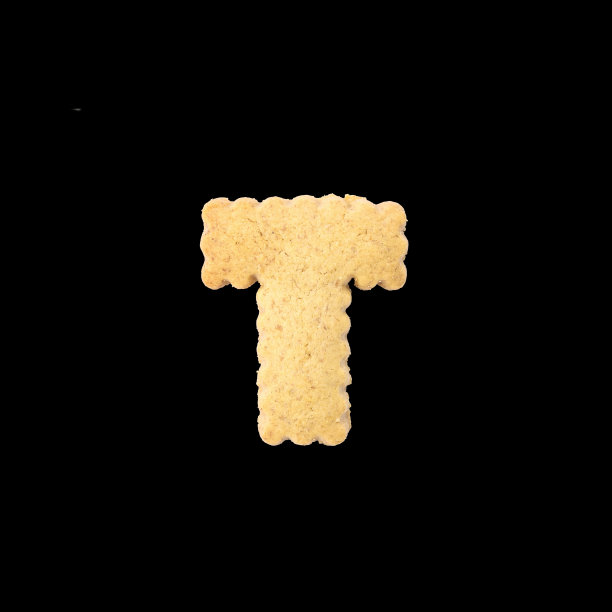 特写棕色饼干在T英语字母孤立在黑色背景与剪切路径图片下载