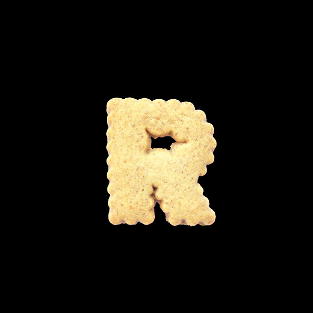 特写棕色饼干在R英语字母孤立在黑色背景与剪切路径图片下载
