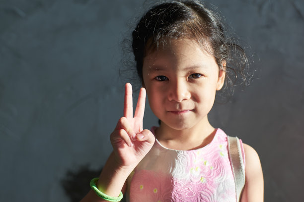 年轻的中国卷发可爱的微笑女孩。图片下载