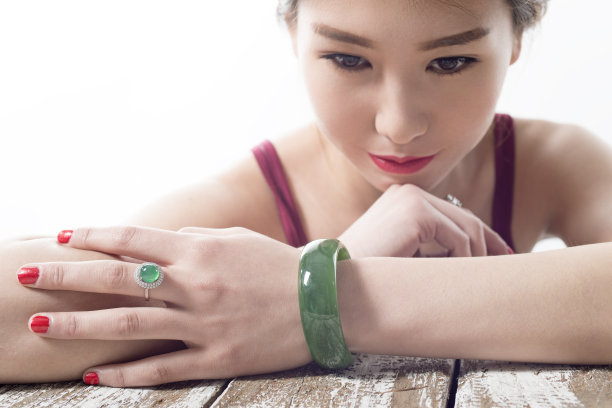 配着玉镯和戒指年轻美丽的女子。图片下载