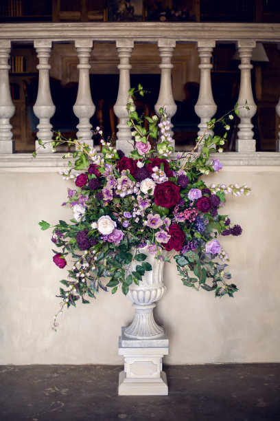 石头建筑里的花瓶里插着紫色的花朵图片下载