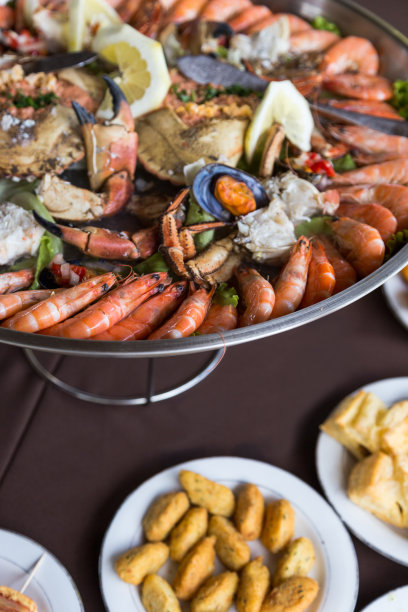 把海鲜和螃蟹装在大金属盘子里放在桌上图片下载