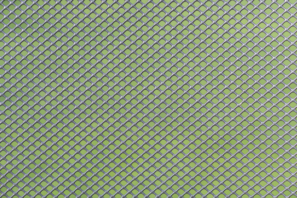 灰色的金属丝网与绿色的背景相映衬图片下载