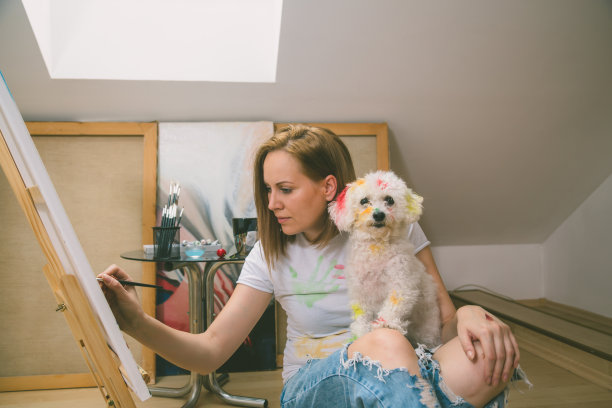 快乐的年轻女子在画布上作画图片下载