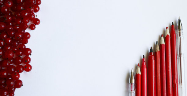 红醋栗浆果和红铅笔和钢笔在一个白色的纸-顶视图图片下载