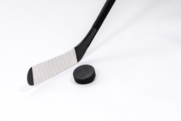 冰球和曲棍球棒在孤立的白色背景，复制空间。图片下载