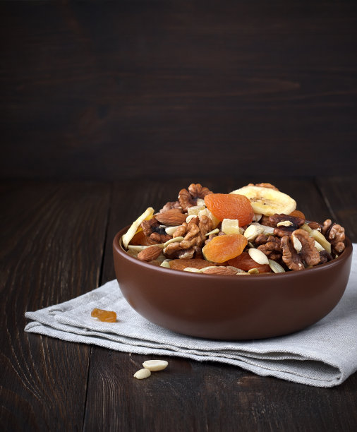 干果和坚果放在桌子上的碗里。图片下载