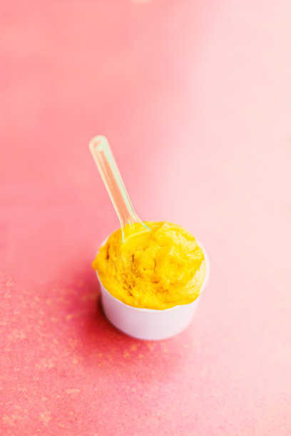 水果圣代冰淇淋在一个白色的纸杯在彩色的背景接近图片下载