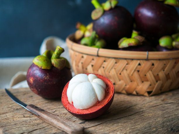 木桌上放着泰国山竹水果。素材图片