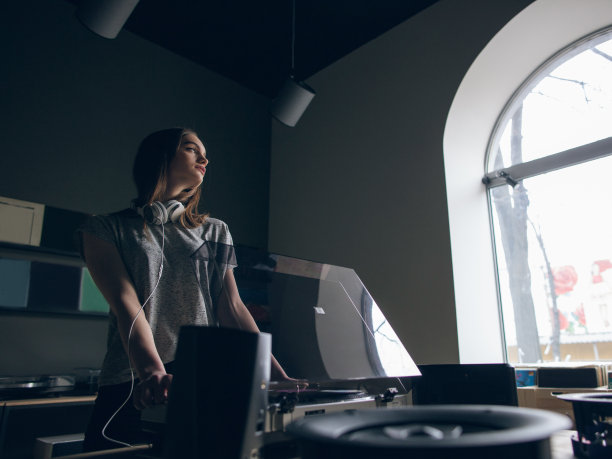 音乐商店。体贴的女孩选择黑胶唱片素材图片