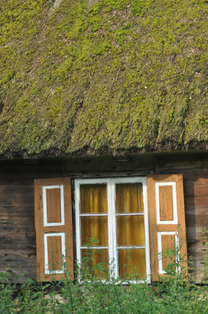有木百叶窗和茅草屋顶的旧木屋。农村建筑。波兰。图片下载