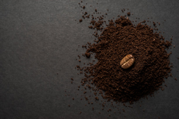 咖啡Bena休息在咖啡粉上的黑色背景图片下载