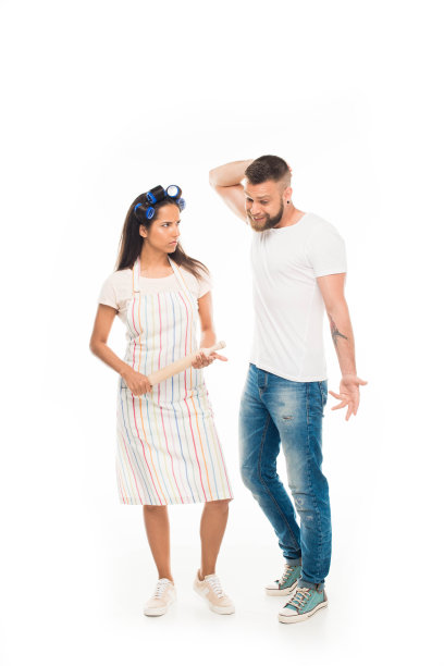 “愤怒的家庭主妇用擀面杖与丈夫发生冲突，孤立于白色。图片下载