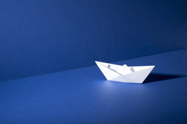 白色的纸船在蓝色的地板和墙壁背景图片下载