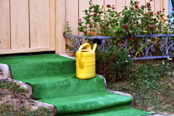 小屋门前石阶上的黄色塑料水桶图片下载