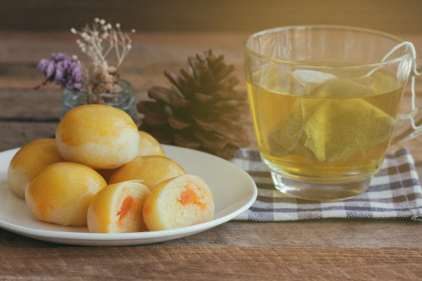 甜绿豆咸蛋的中式糕点。绿豆沙和咸蛋馅的月饼或中式糕点与绿茶一起食用。美味的自制中式糕点即将上桌。图片下载