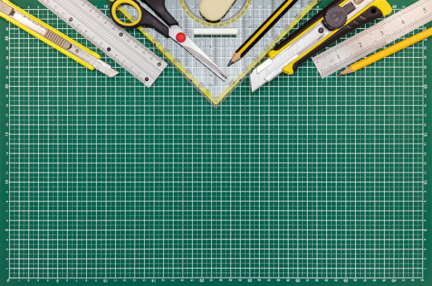 课桌上有绿色切割垫，备有学习或办公用品图片下载