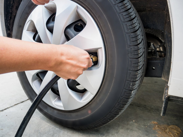 男人给汽车轮胎充气图片下载