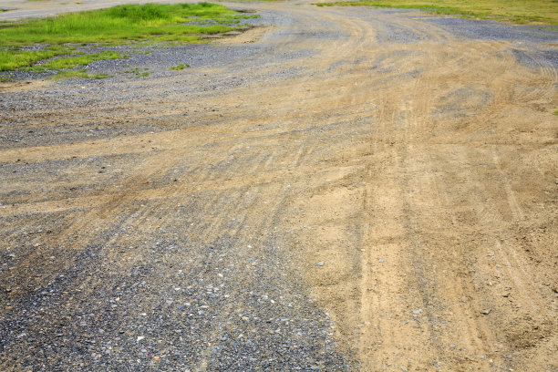 草地砾石地面上的车轮痕迹图片下载