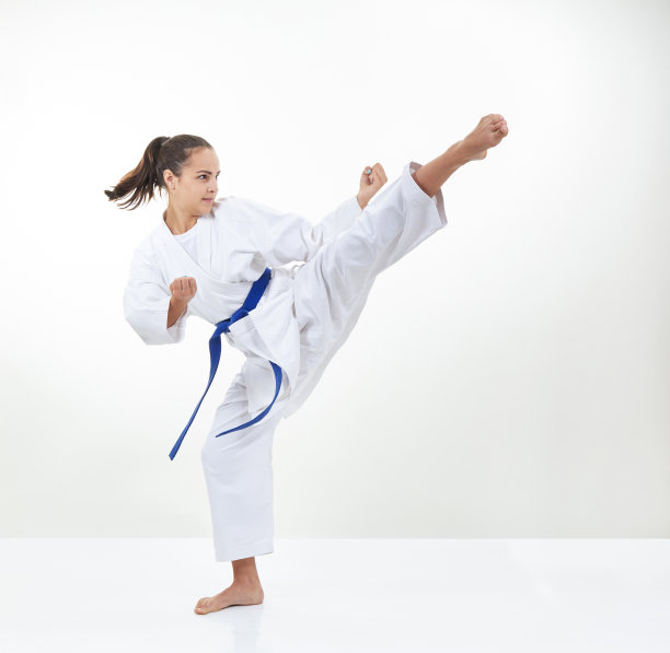 一个穿着蓝带的运动员训练踢腿图片下载