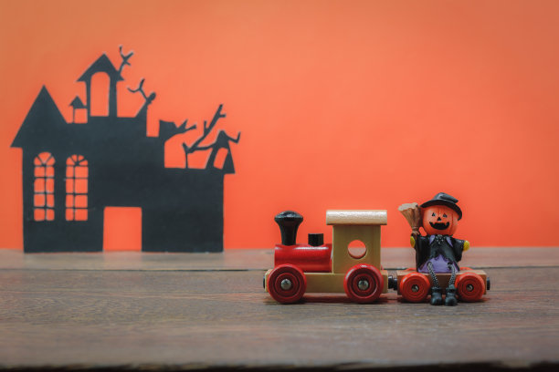 万圣节快乐概念配件。必要的装饰在现代棕色木制办公桌的背景与橙色墙纸和复制空间。混几个是旺季的签和准备。图片下载