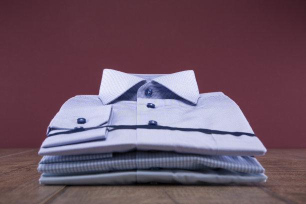 男人的衬衫放在一张木桌上。折叠。背景勃艮第。图片下载
