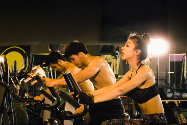 三人一组在室内健身房里骑自行车进行有氧运动训练。图片下载