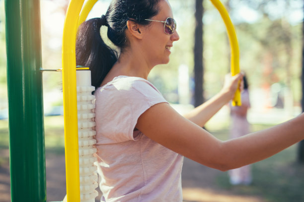 女人在公园的模拟器按摩器锻炼图片下载