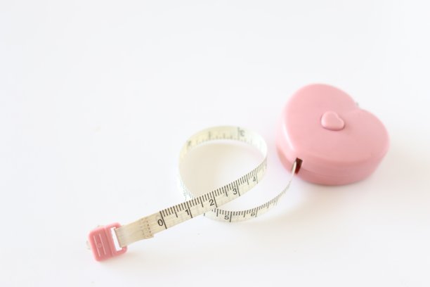 白色背景上的白色和粉红色卷尺的绞丝，图片下载