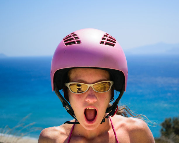 戴着粉色头盔的年轻兴奋女性图片下载