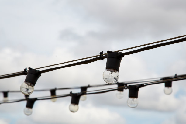 把电线灯泡串在户外场地上图片下载