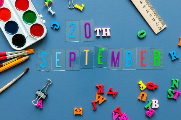 9月20日。月的第20天，回到学校的理念。日历上有老师或学生的工作背景，蓝色的桌子上有学习用品。秋天的时间图片下载