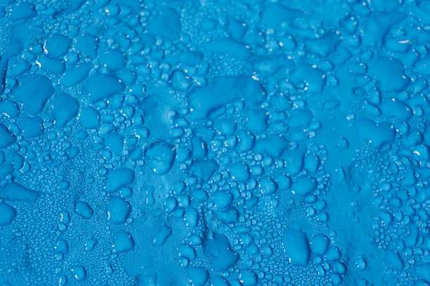 不同大小的水滴落在光滑的蓝色表面上图片下载
