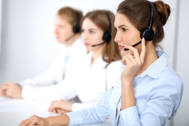 呼叫中心。关注戴着耳机的美丽商务女性图片下载