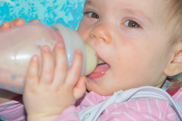 特写镜头，和一个奶瓶宝宝一起吃，看着镜头图片下载