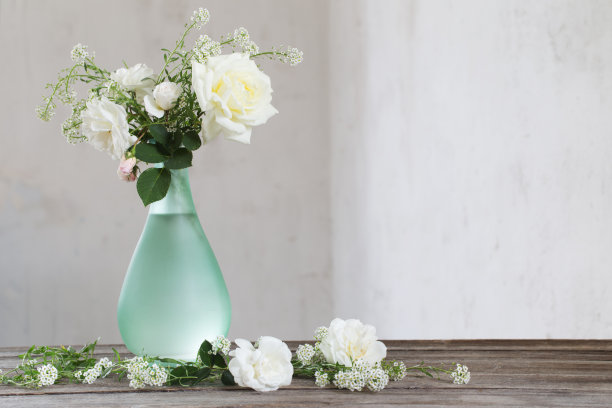 木桌上的绿花瓶里插着白玫瑰图片下载