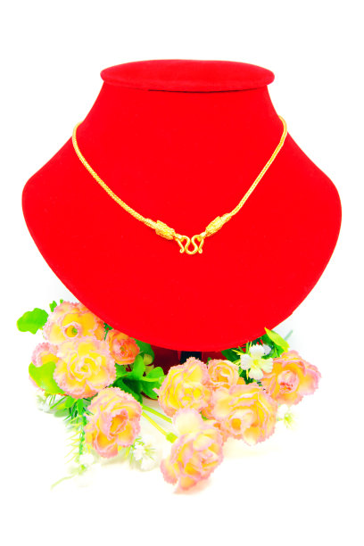 金项链戴在红布上，孤立在白布上图片下载