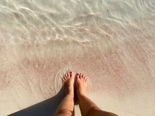 女人的脚在粉红色的沙滩上(西西里，意大利)图片下载